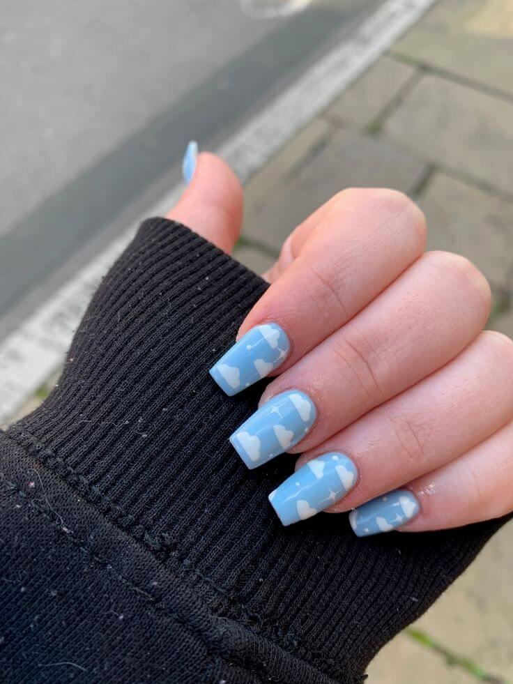 Baby blue nails with fluffy white clouds by nailbeautyguide