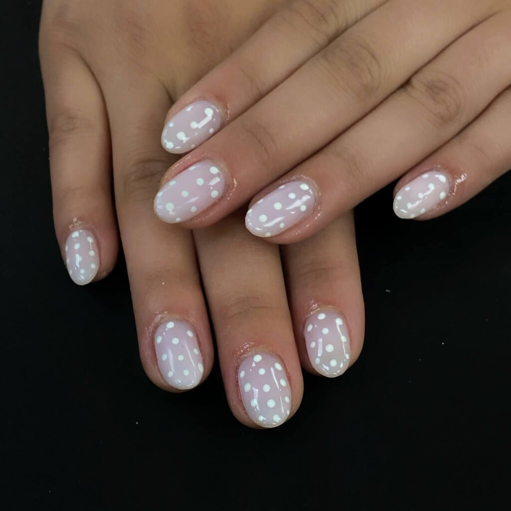 Black polka dots painted neatly on a glossy white base by purenailspa2018