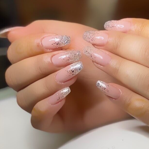 Glitter fading from the tips to the base of almond-shaped glossy white nails by toucherdeplumes