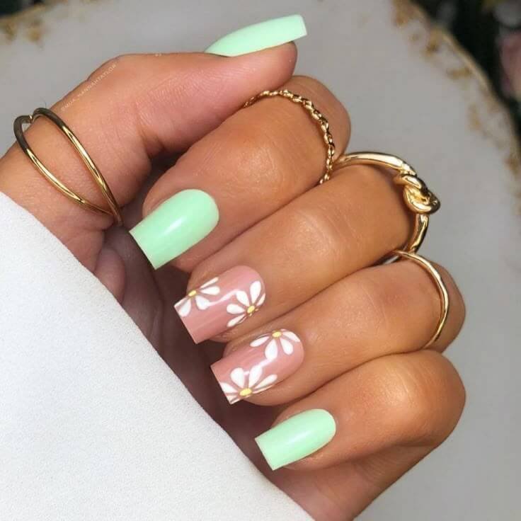 Mint green nails with delicate daisy patterns by nailbeautyguide