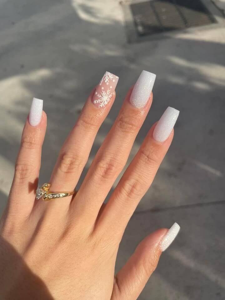 Snowflake designs painted with silver glitter on a glossy white base by nailbeautyguide