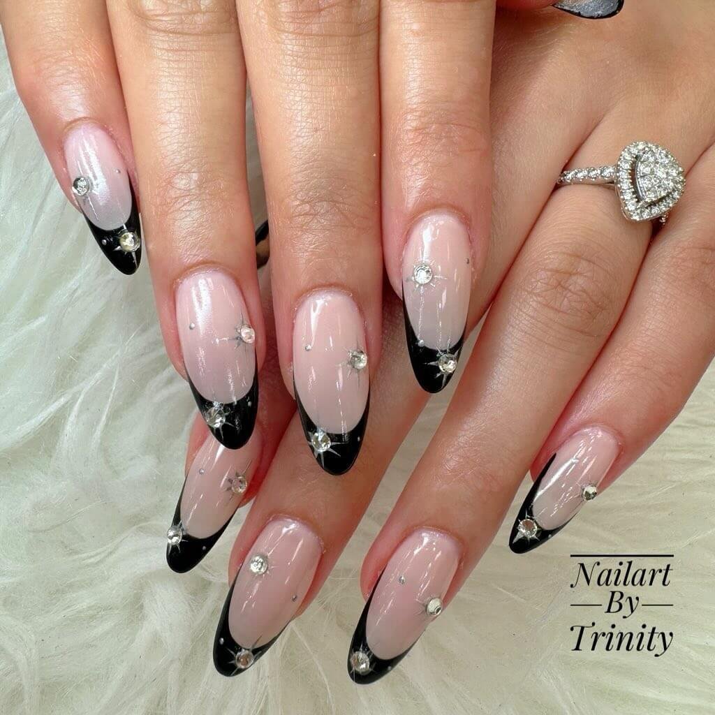Black French tips with rhinestones placed along the edges by nail.art.by.trinity