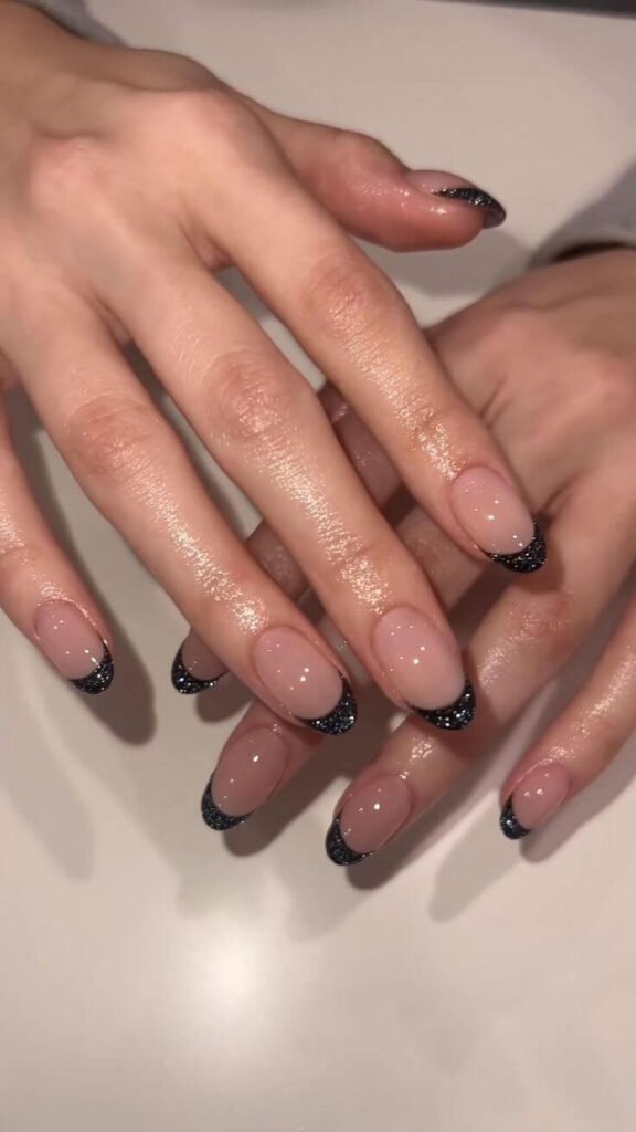Black glitter tips on a nude or clear base by nailbeautyguide