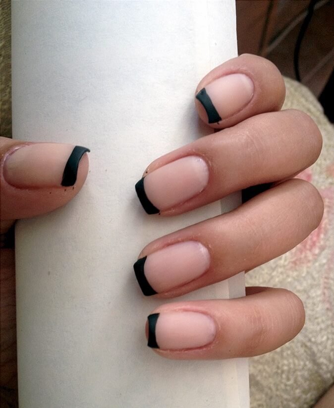 Coffin-shaped nails with matte black tips and soft beige base by nailbeautyguide