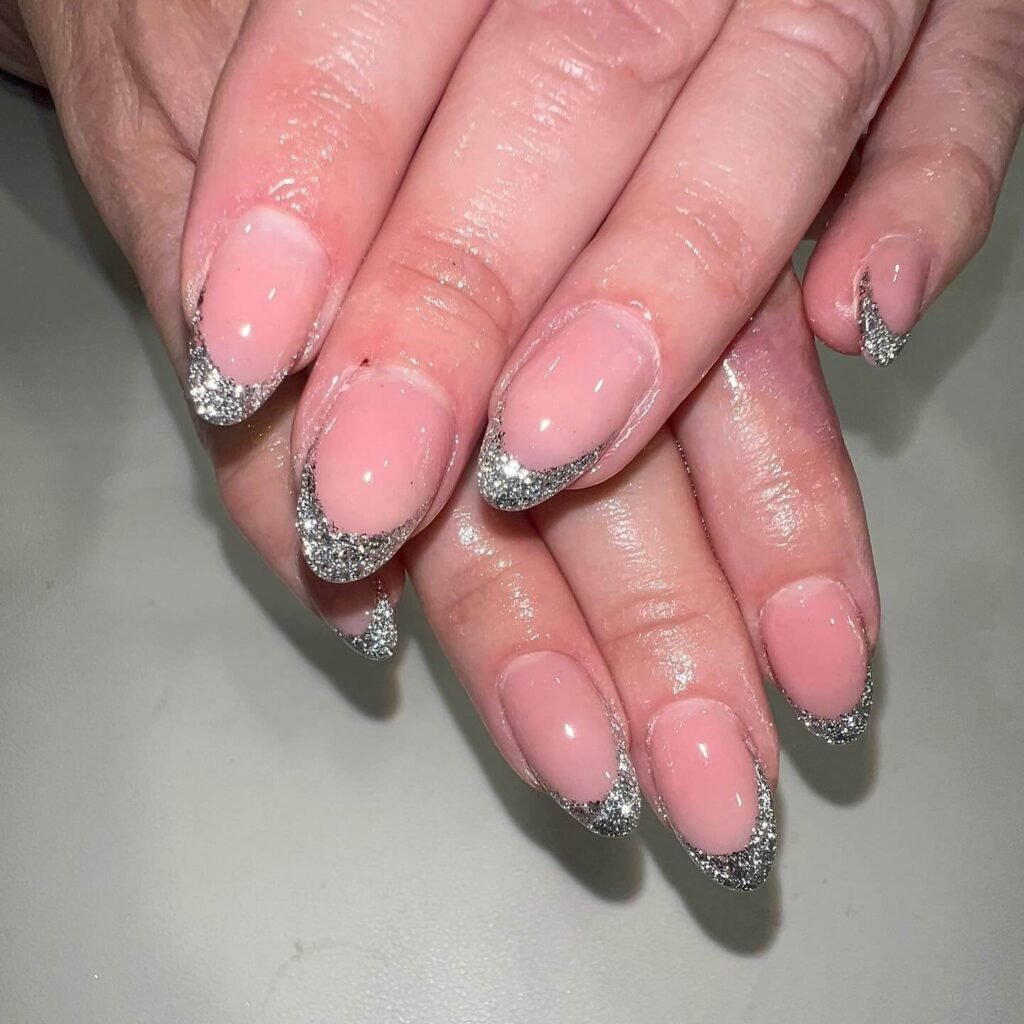 Glitter base French tips styled with festive decorations by _nailkorner_