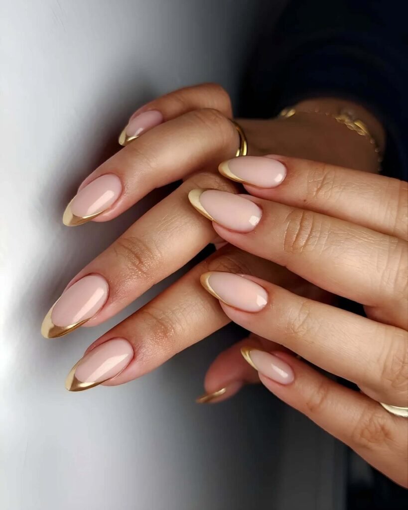 Gold foil French tips styled with metallic accessories by jark.nails