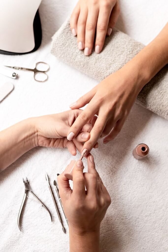 Hands being treated at a nail salon by nailbeautyguide