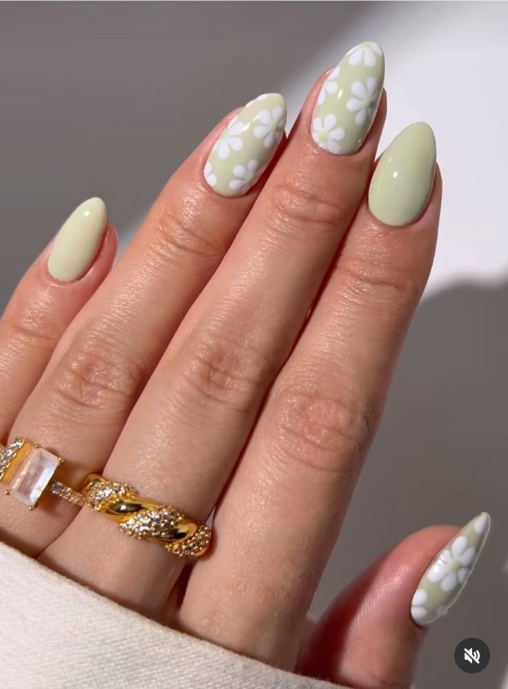 Sage nails with delicate white flower motifs by nailbeautyguide