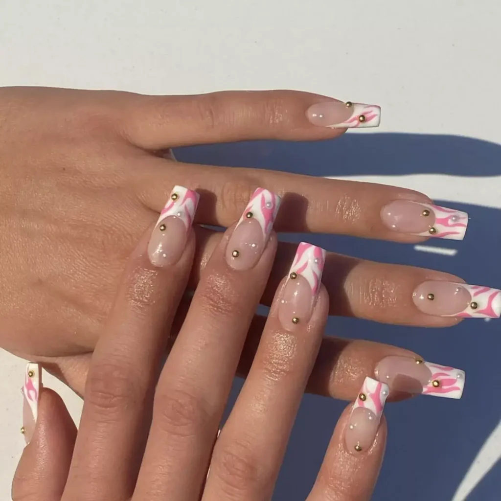 Pink and white French tip nails with embellishments by nailtherapy.co