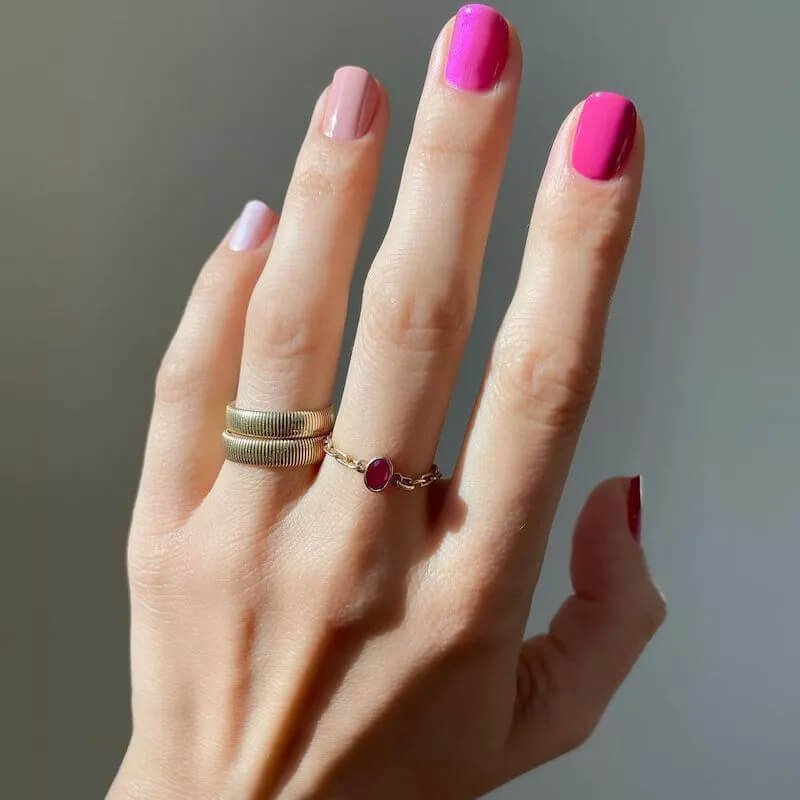 Short, rounded nails covered in a bold, electric hot pink or fuchsia polish by betina_goldstein