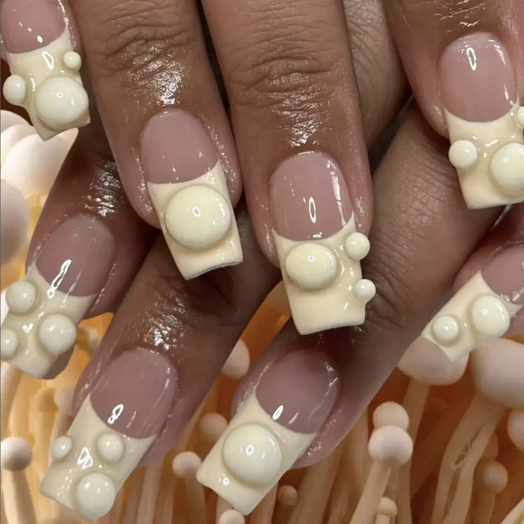 White French tip nails with mushroom-inspired accents by manicures.nyc
