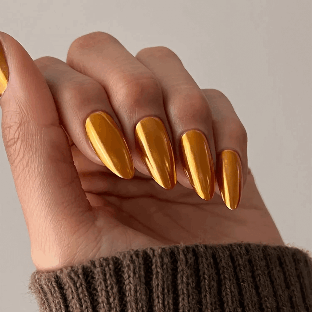 Long nails painted in a shiny pumpkin orange chrome finish. by overglowedit
