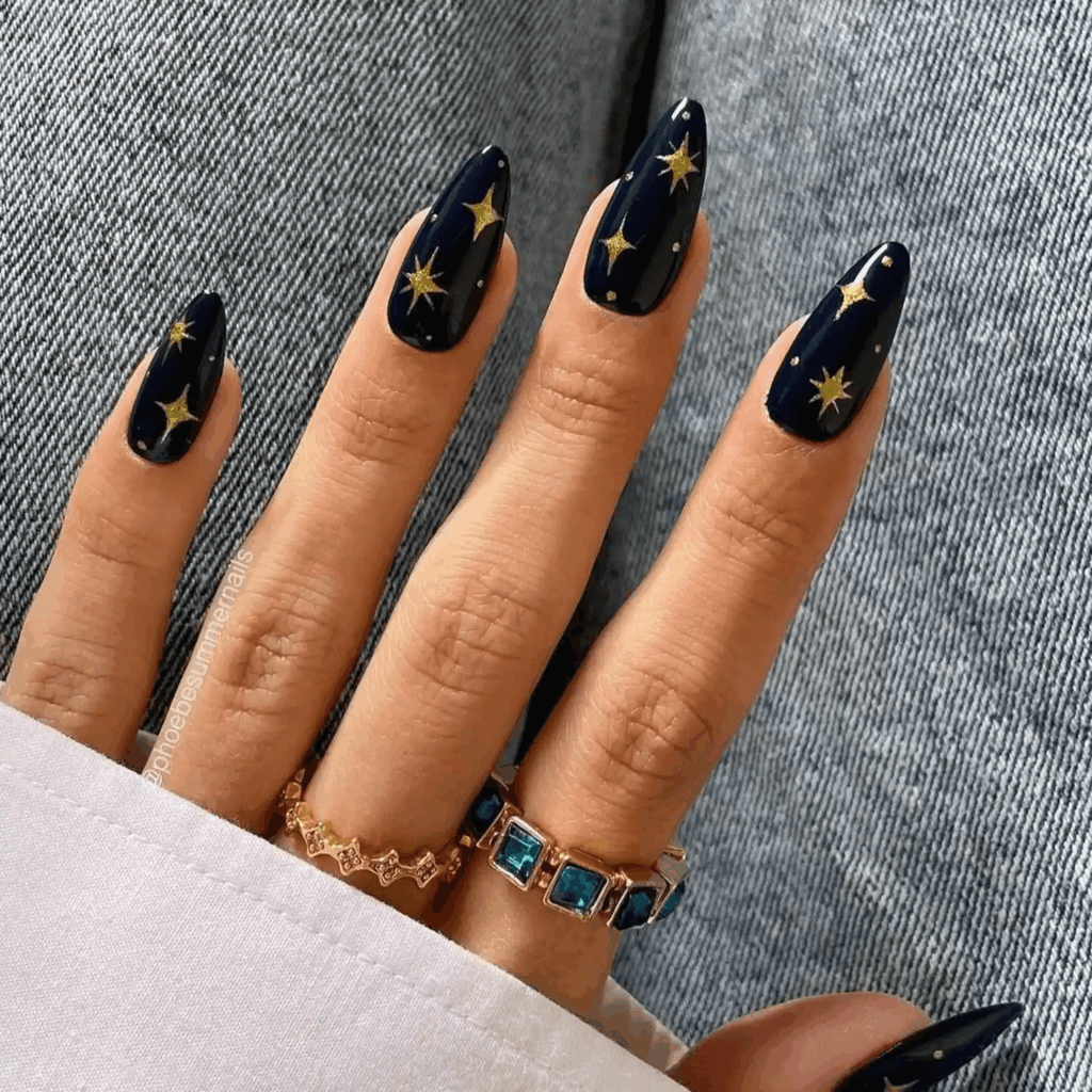 Navy blue almond nails with tiny gold starburst and dot accents. by thehangedit
