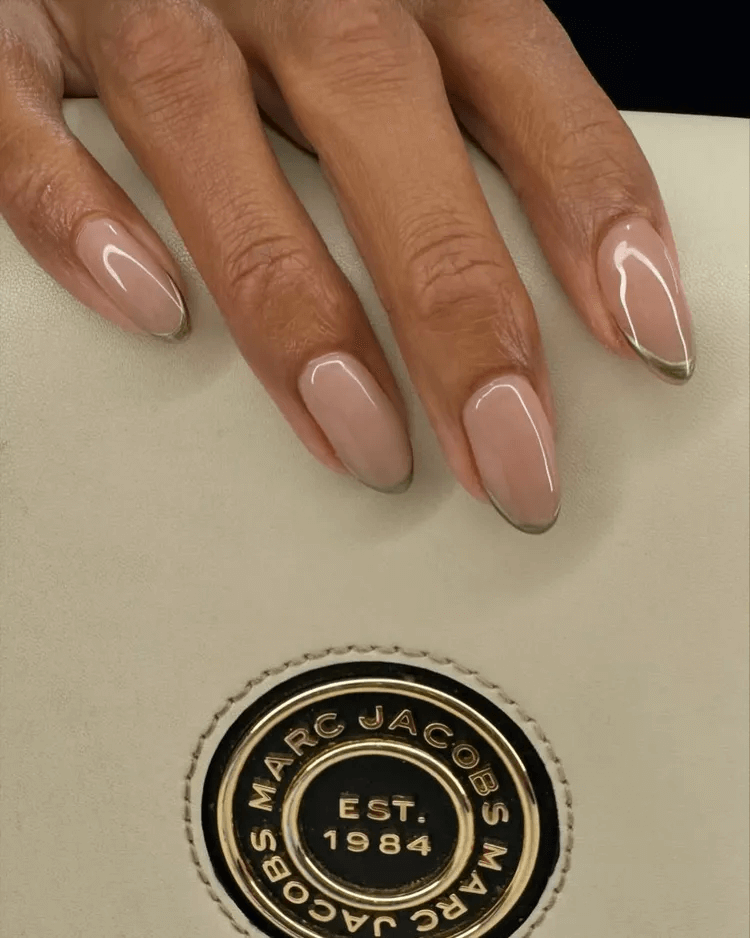 Nude nails with a very thin, shimmery gold chrome French tip. by tipsxtara