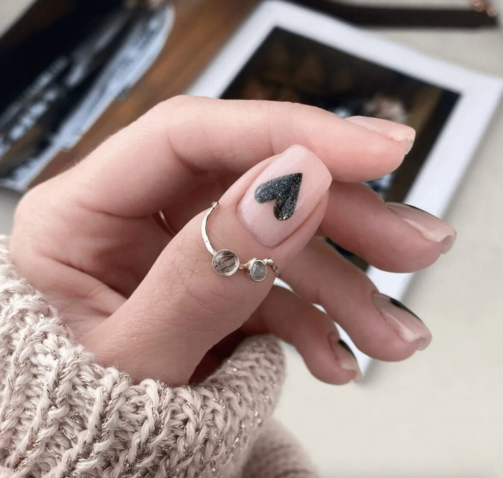Nude square tips with black glittery heart designs. by anetaujwary