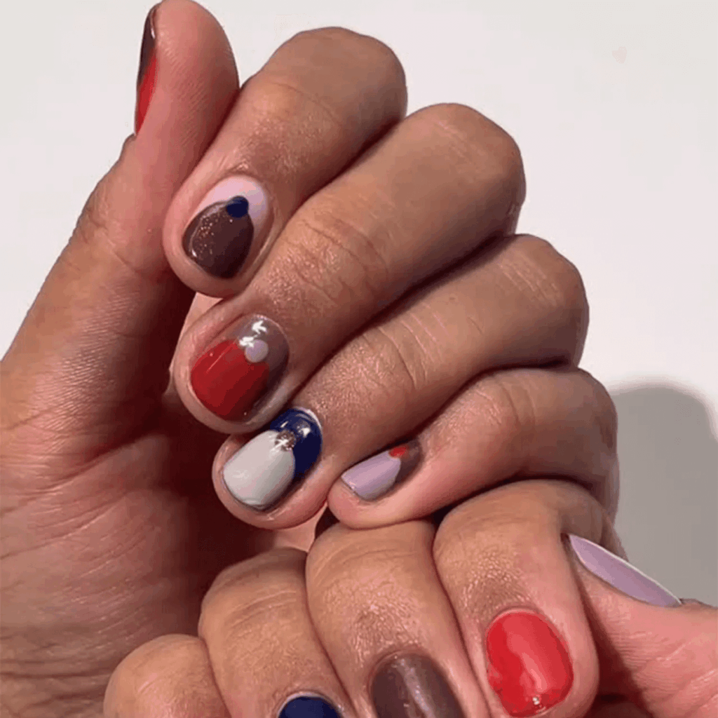 One hand with simple solid polish, the other with intricate fall designs. by oliveandjune