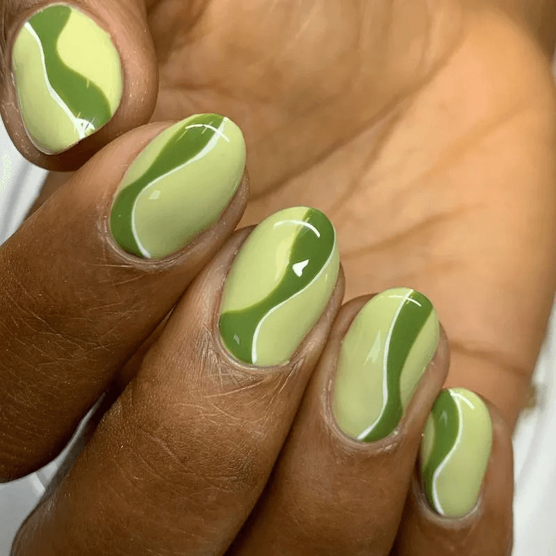 Short acrylics with green swirl designs. by paragonnails