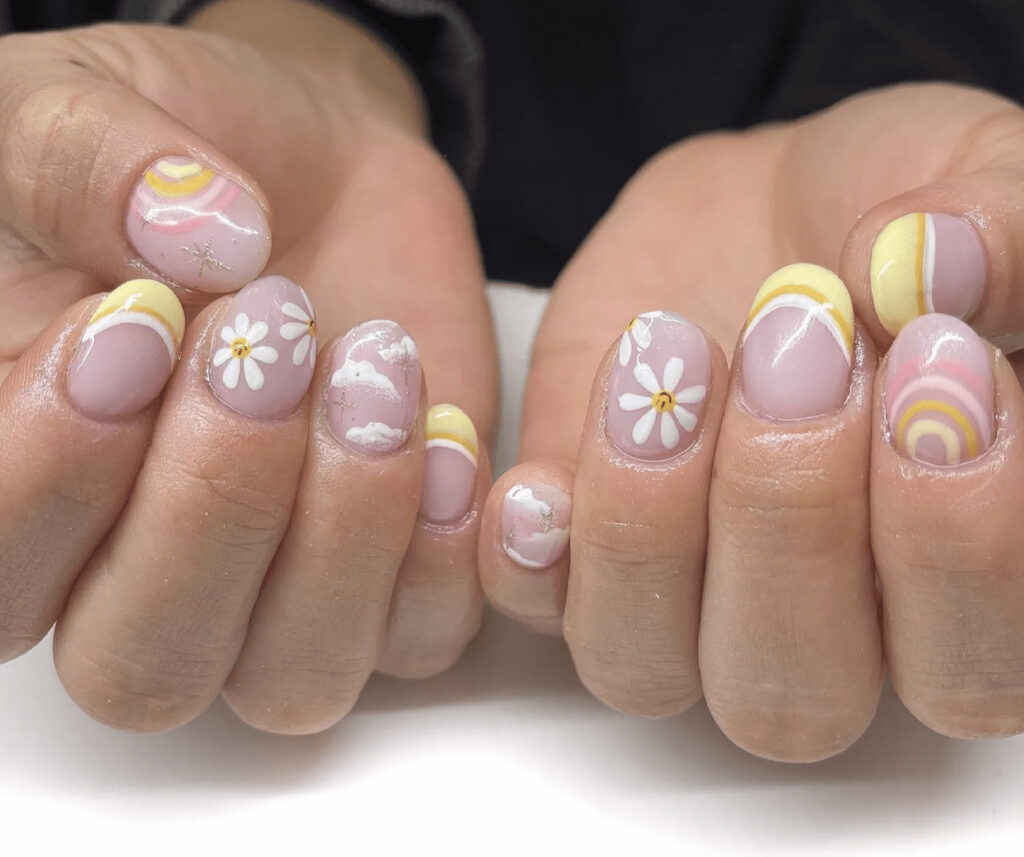 Short rounded acrylics with daisy and rainbow designs. by nailsby.hails