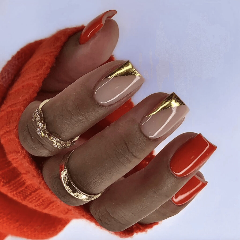 Short, square acrylics with mismatched red and gold design. by glammertized