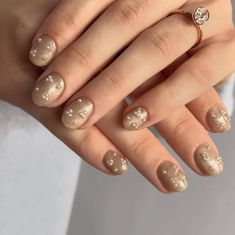 Short taupe nails adorned with tiny pearl and bead accents. by gossipandgloss
