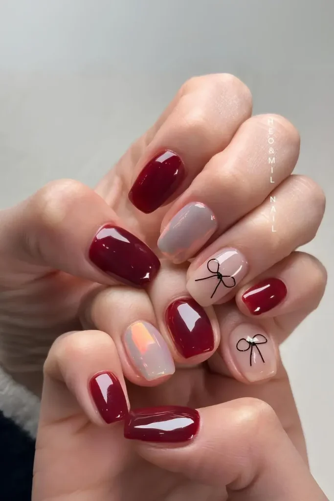 Alternating dark red and white chrome nails with hand-drawn black bows. by heojinhee_nail

