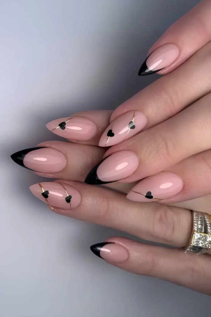 Black French tips with gold accent lines and black hearts. by natmaloneynailartist