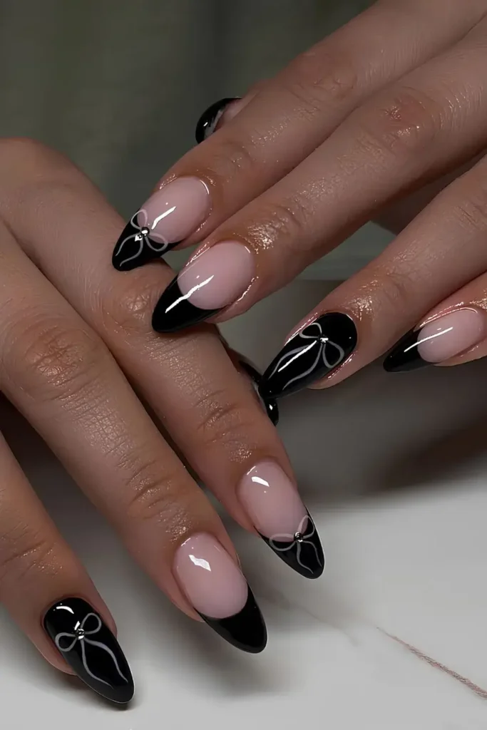 Black nails with tiny white bow accents. by nails.miastudio