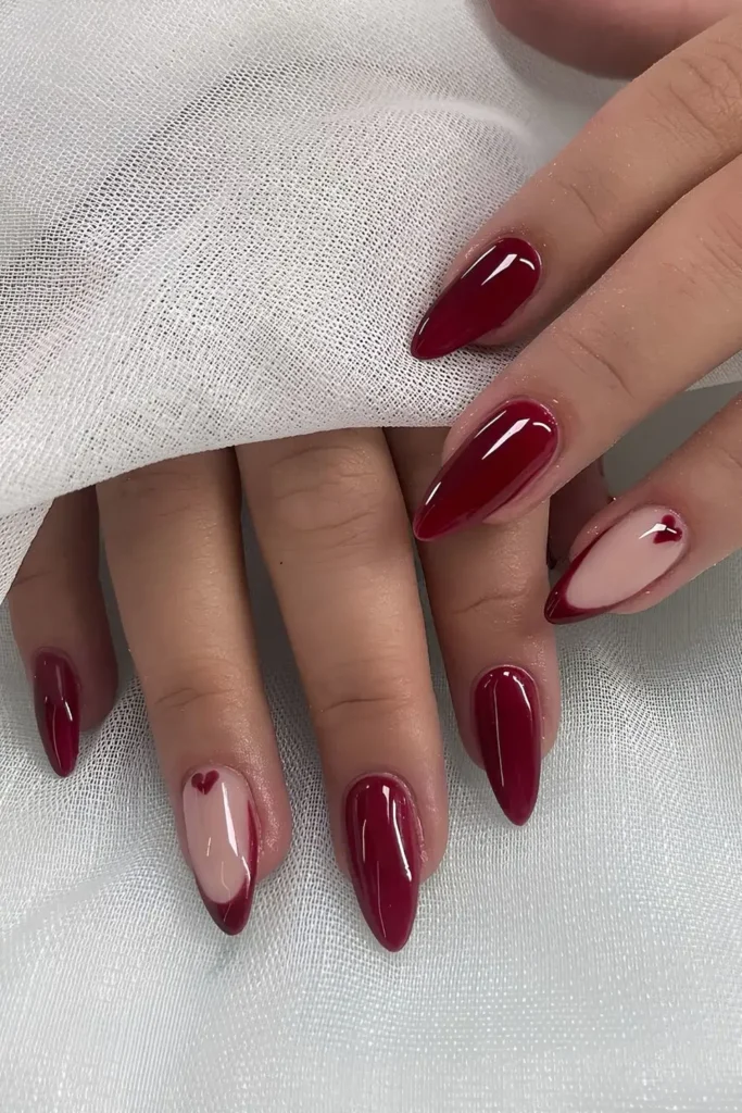 Cherry red nails with a heart accent on one nail. by studiodrita