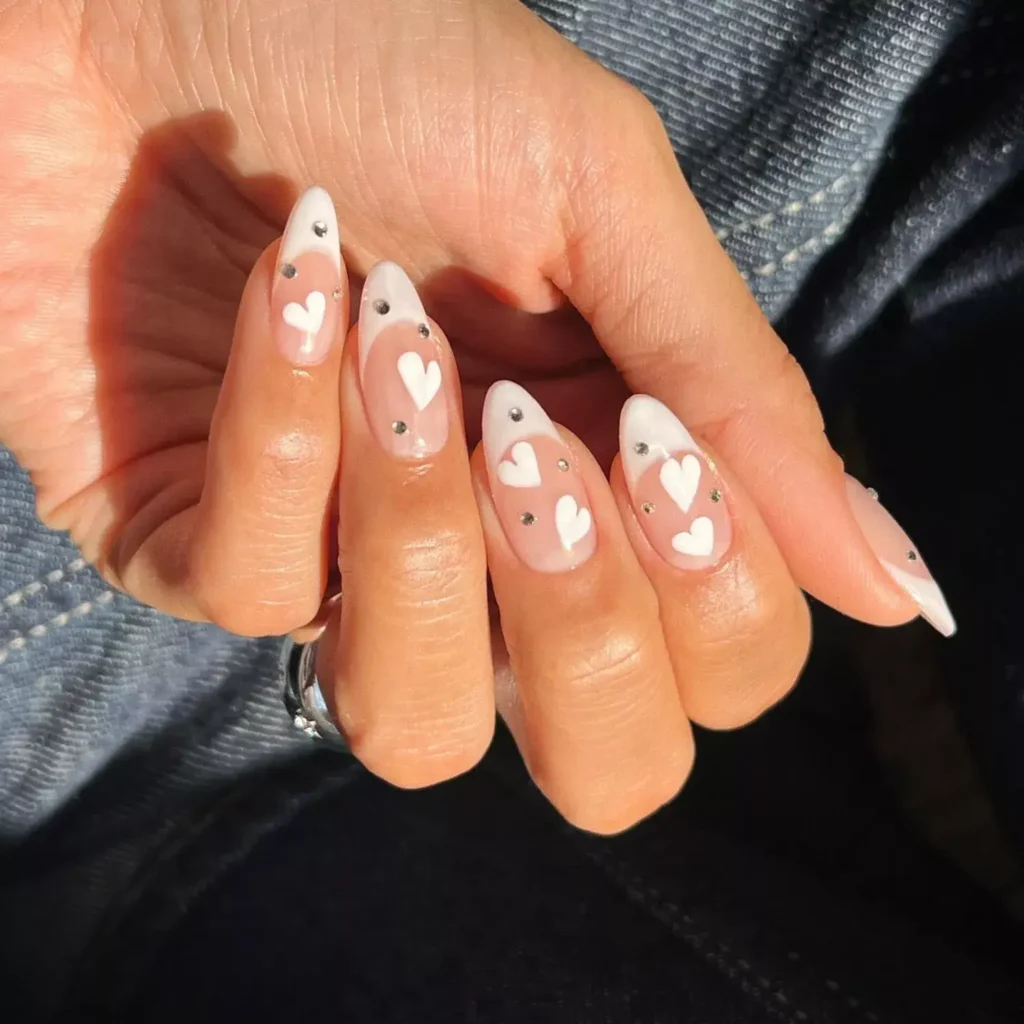 Classic French manicure with playful white heart accents. by overglowedit