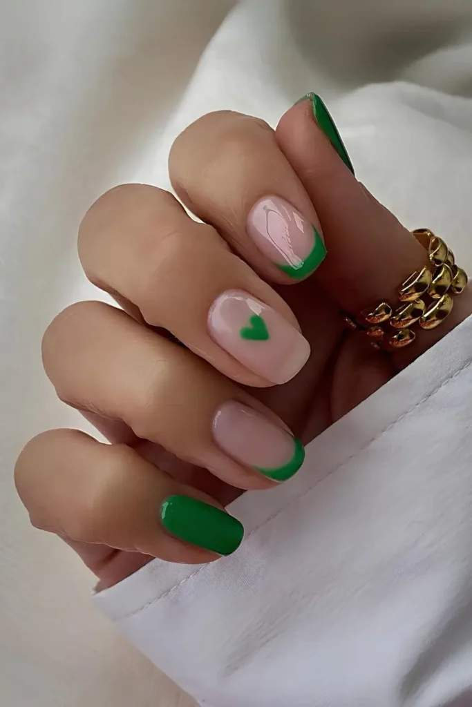 Green French tips and solid nails with heart accents. by lindseysbeautylounge1