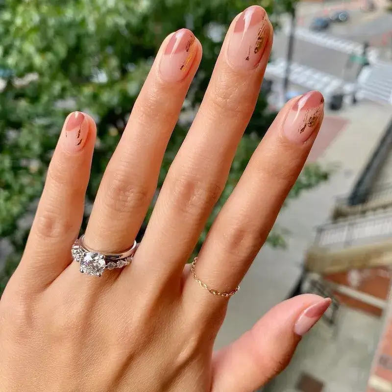 Image of clear nails with small, scattered gold foil flakes randomly placed over the nail plate. by amyytran
