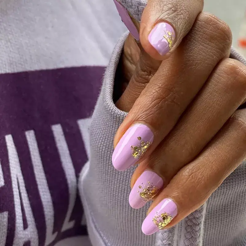 Image of lilac nails with carefully placed gold foil detail near the cuticle. by paintboxnails