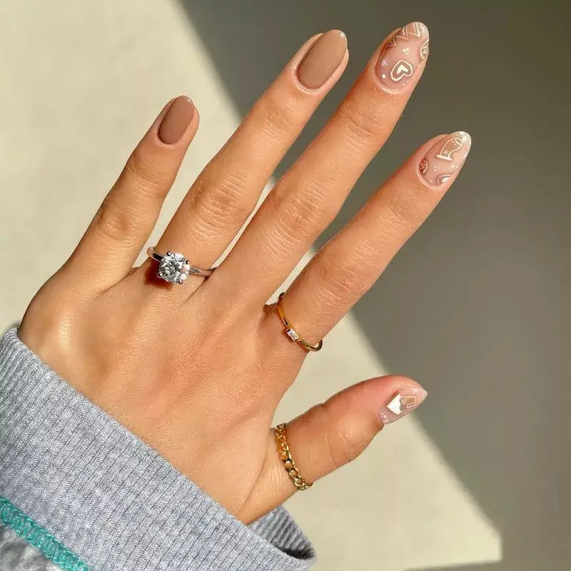 Image of nails painted clear with small white hearts and fine white lines resembling winter designs. by amyytran