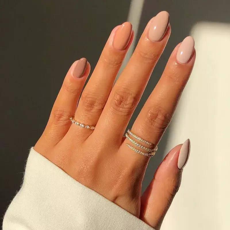 Image of nails painted in alternating neutral tones, creating a subtle, graduated ombré effect across the hand. by iramshelton
