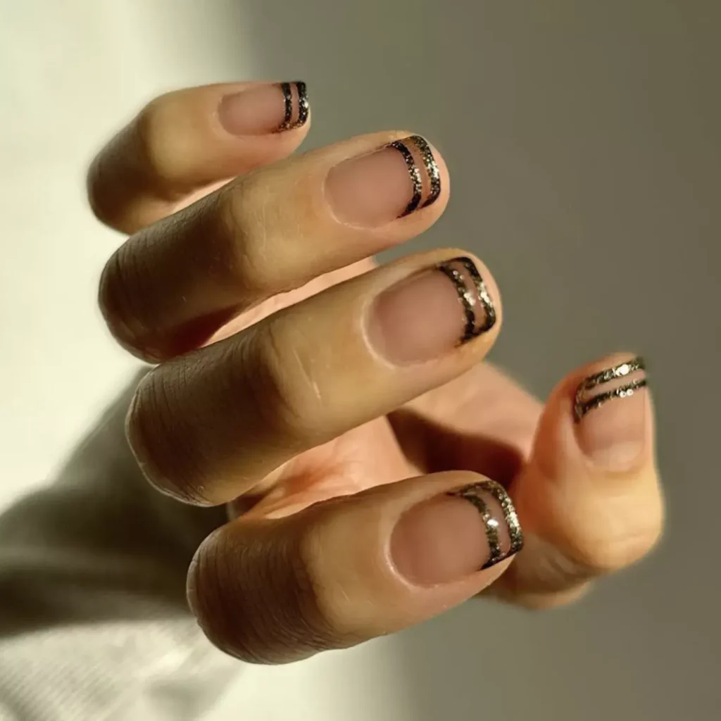 Image of pale neutral nails with two thin, parallel gold lines painted on the tip. by thehangedit