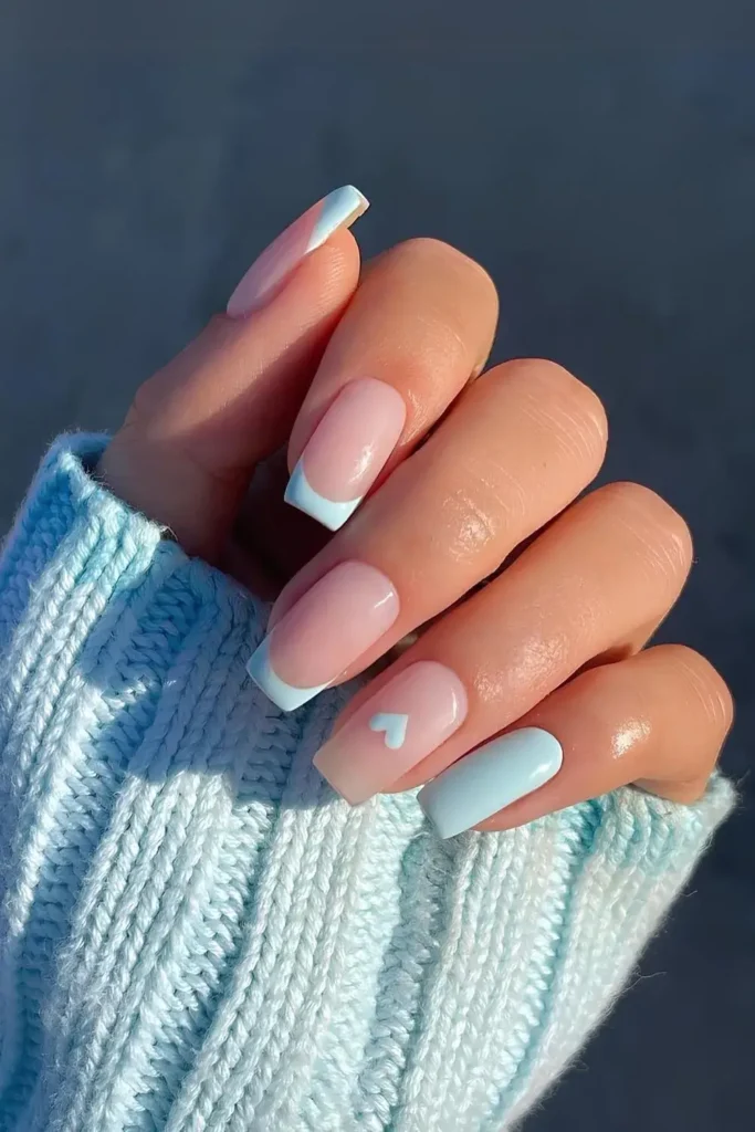 Light blue nails featuring French tips and a small blue heart accent. by gelsbybry