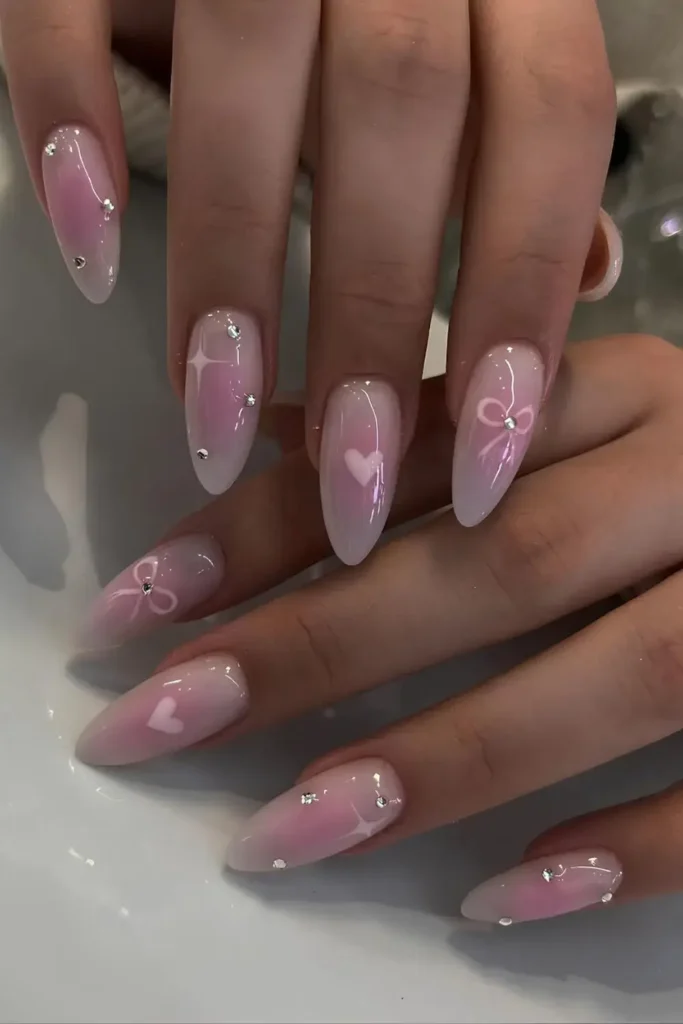 Milky nails with a pink aura effect, hearts, and tiny rhinestones. by giangnail.ie
