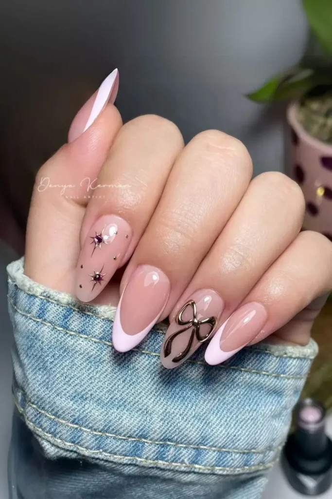 Pink French tips with a chunky chrome bow and starbursts. by studiodk_mx