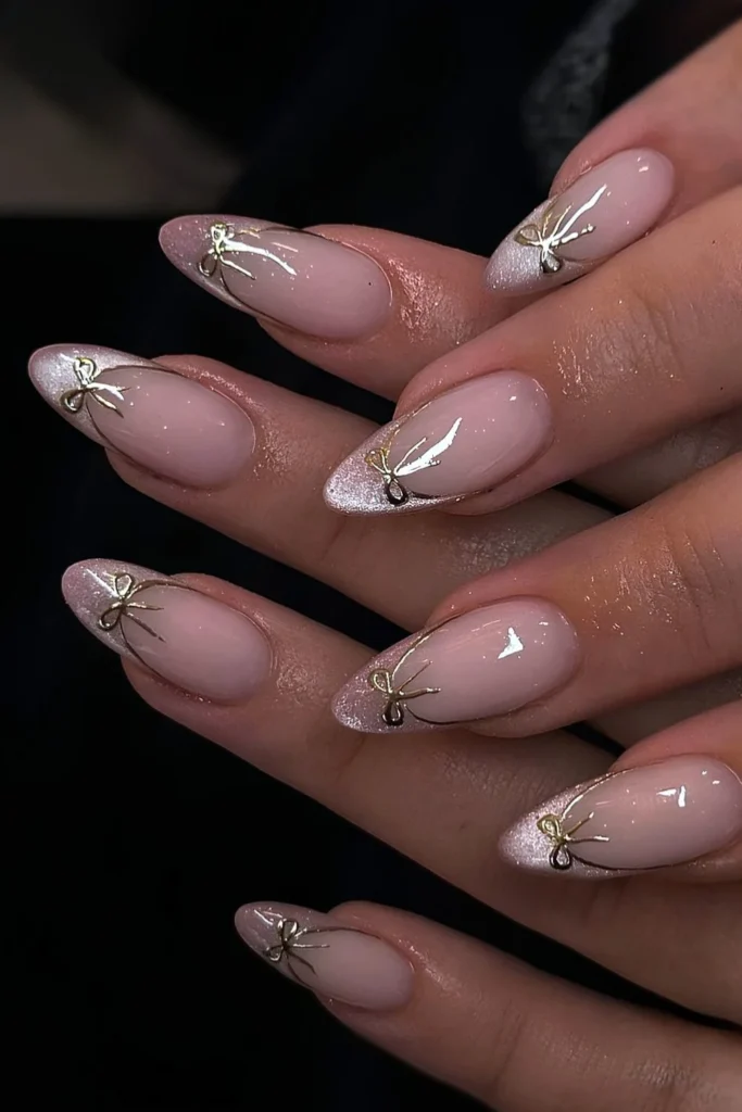 Pink cat eye French mani with gold bows. by giangnail.ie