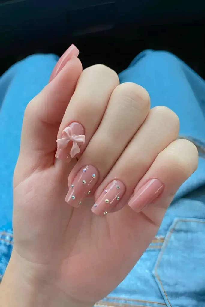Pink nails completely covered in rhinestones and topped with 3D pink bows. by nailbeautyguide