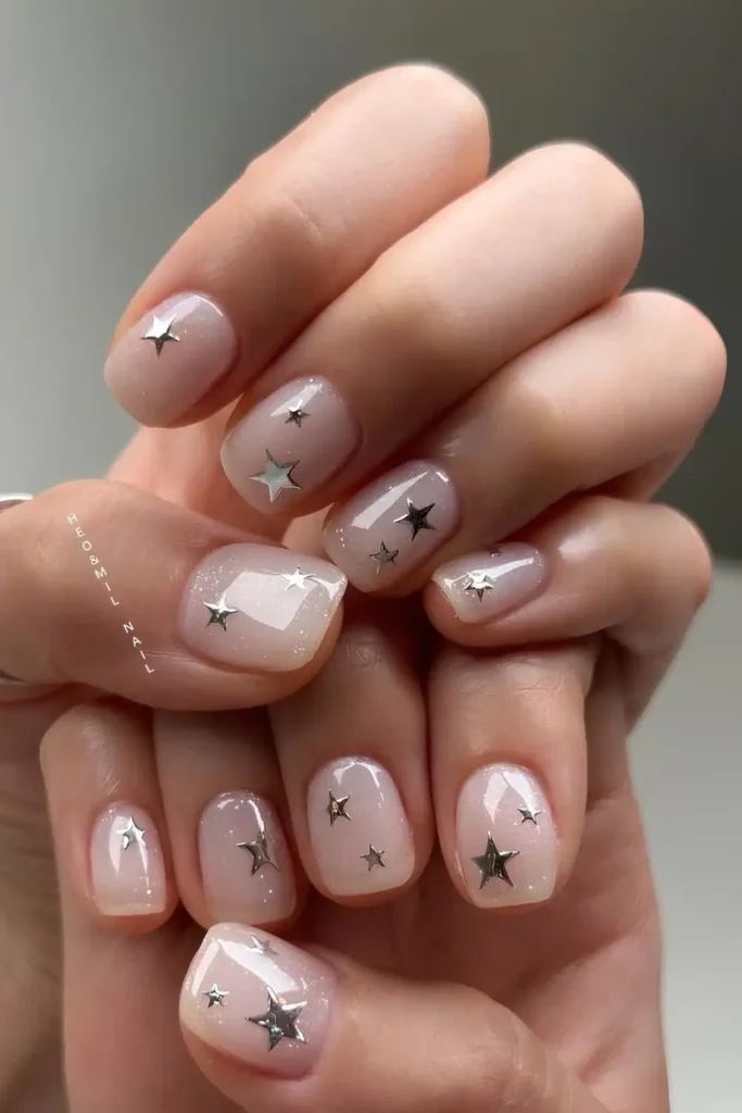 Sheer white nails with silver chrome stars. by heojinhee_nail

