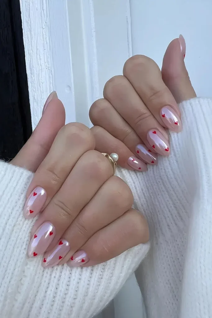 Soft pink chrome nails with tiny red hearts. by hairnnailsbykam
