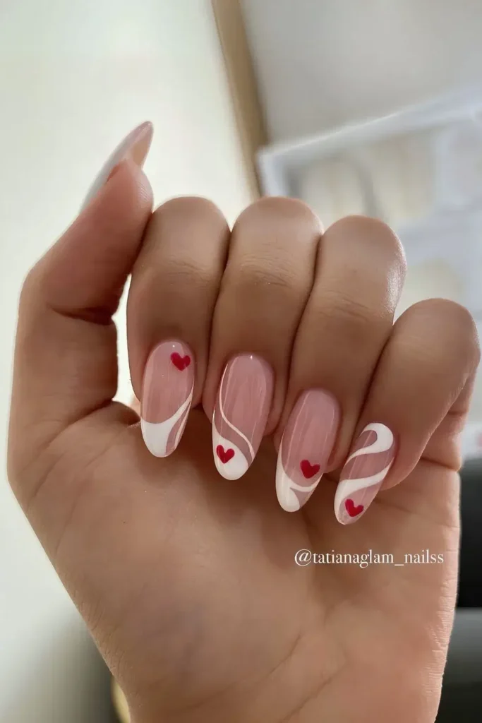 Swirly white French tips with tiny red heart accents. by tatianaglam_nailss