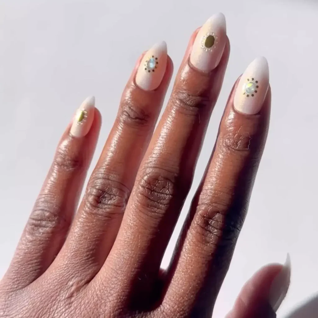 White nails decorated with delicate gemstone accents. by lolo.nailedit
